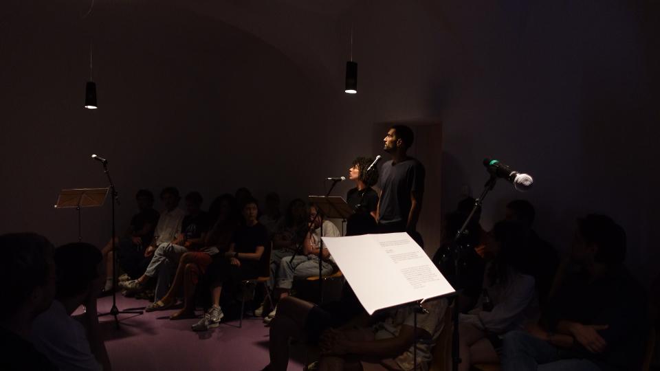 two people standing in a room behind an microphone